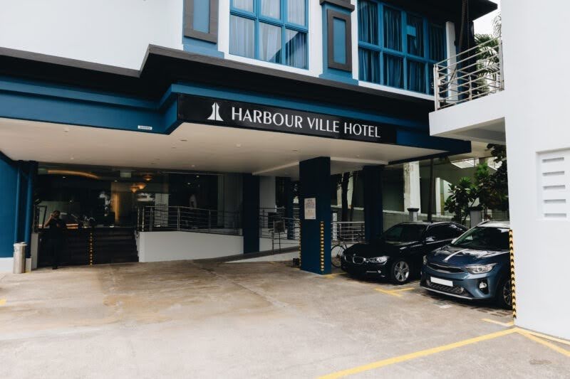 Entrance and driveway of Harbour Ville Hotel with parked cars